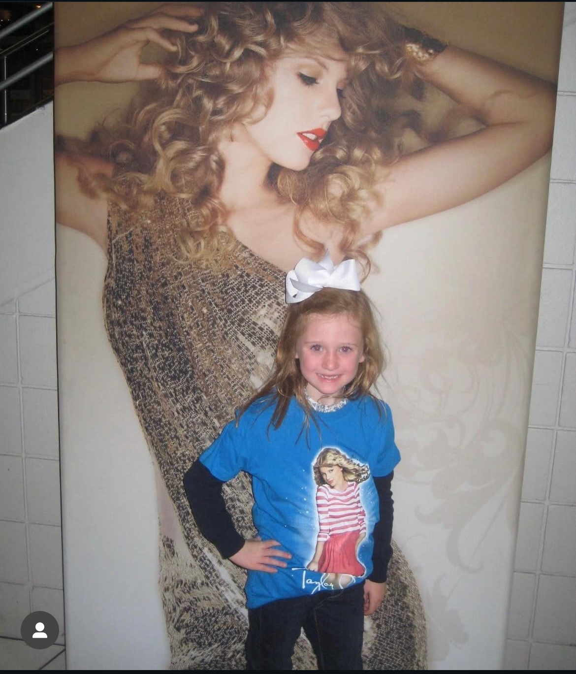 Fan posing in front of Taylor Swift poster